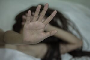A victim of a violent crime holds up her hand towards the camera. 